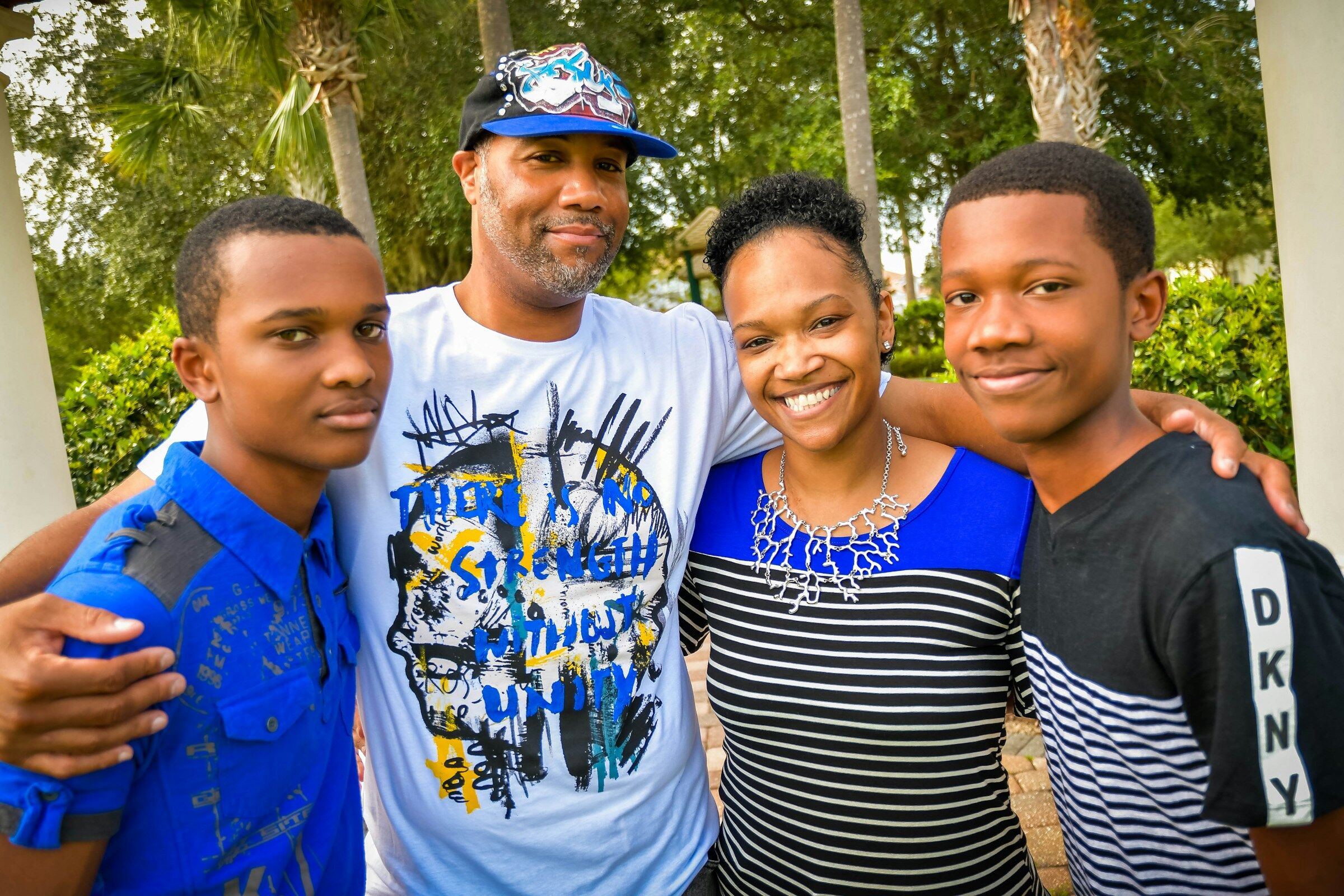 A smiling Black family together outdoors